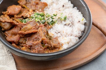 Jeyukdeopbap, Korean Food Spicy Stir-fried Pork with Rice in Black Bowl 