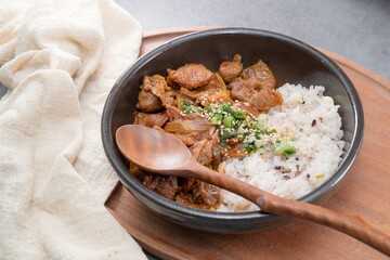 Jeyukdeopbap, Korean Food Spicy Stir-fried Pork with Rice in Black Bowl 