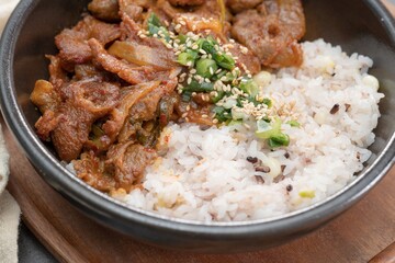 Jeyukdeopbap, Korean Food Spicy Stir-fried Pork with Rice in Black Bowl 