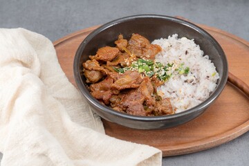Jeyukdeopbap, Korean Food Spicy Stir-fried Pork with Rice in Black Bowl 