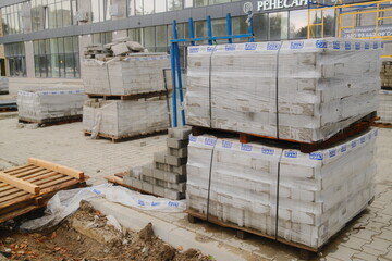 Gray pavers, wrapped, near building on site.