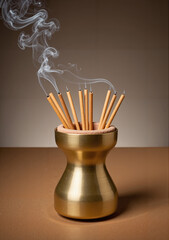 Incense sticks burning in a golden holder with smoke, concept of Lunar New Year  