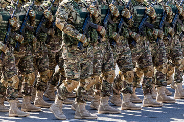 Large group of men in military uniform marching outdoors