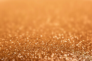 A shimmering golden glitter background with soft bokeh lights creating a luxurious and festive abstract texture.