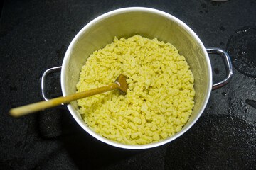 Preparing food at own kitchen with top view of home made Spätzle in a metal pan on an autumn evening. Photo taken October 6th, 2025, Zurich, Switzerland.