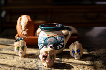 Sugar skulls and bread decorating a traditional mexican offering