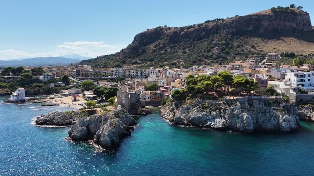 Sant Elia bay beach in Porticello town, Santa Flavia, Sicily, Italy, aerial drone view of Sicilian turquoise waters, rocky cliffs, colorful houses, and Mediterranean coastline panorama in Bagheria