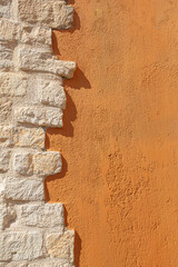 Stone brick wall contrasting orange plaster texture