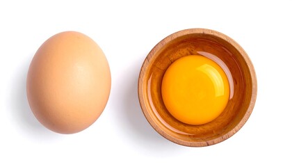 Whole brown egg beside wooden bowl with yolk