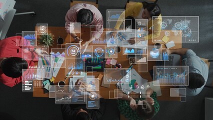 A group of professionals engages in a collaborative business meeting, exploring data visualizations and graphs on digital screens while fostering creativity and teamwork. Raster