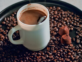 A Steaming Hot Cup of Coffee Served with a Chocolate Truffle - A Beautiful and Aromatic Still Life with Coffee, Beans, and Chocolate