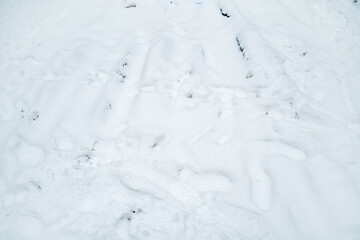 Background with uneven white snow. Winter texture with lumps of snow.