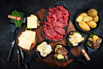 Traditional authentic swiss raclette with beef meat, boiled potatos, green beans and mushrooms...