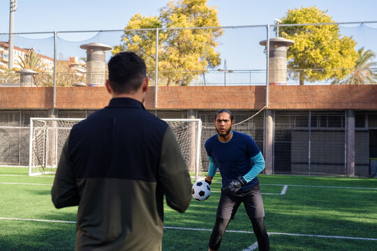 Focused goalkeeper working out with coach