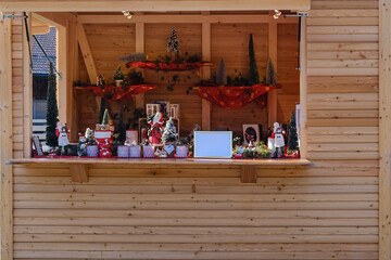 A rustic wooden market stall displays handcrafted gifts and holiday decorations at a seasonal market in Germany.