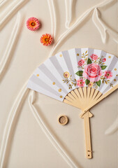 Decorative fan with floral design and flowers on soft fabric background, Concept of Lunar New Year  