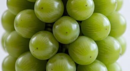 Obraz premium Close-up of a dense cluster of fresh green plums creating a vibrant natural pattern