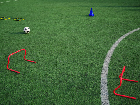 Training equipment and soccer ball on football pitch