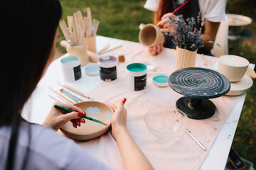 Ceramic bowl with painted blue designs inside. Blue paint drawings inside ceramic bowl. Ceramic bowl decorated with blue paint designs shows detailed process of pottery painting of handmade ceramics.