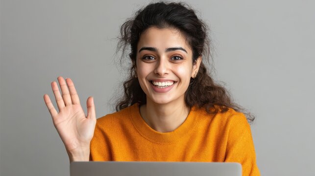 happy indian girl holding using laptop looking at computer screen make conference online call smiling young hindu woman user waving hand  doing internet video chat isolated on grey studio background 