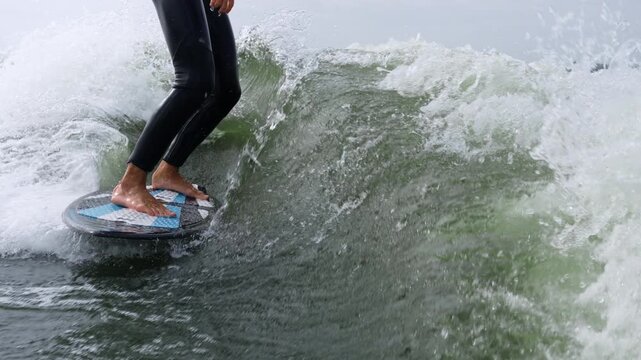 Surfer skillfully rides a wave, showcasing balance and agility in dynamic water action