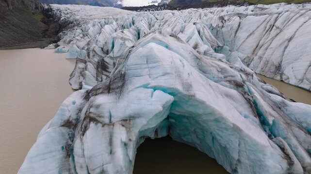 Close-up aerial of a meltig glacier with an ice archin Iceland.