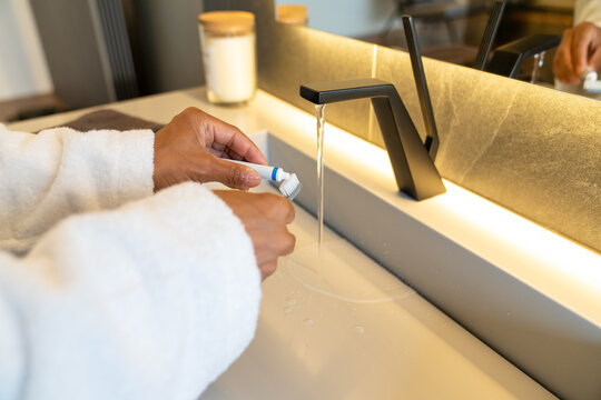 Close-Up of Woman Squeezing Toothpaste onto Toothbrush