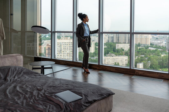 Businesswoman Admiring City View from Hotel Suite
