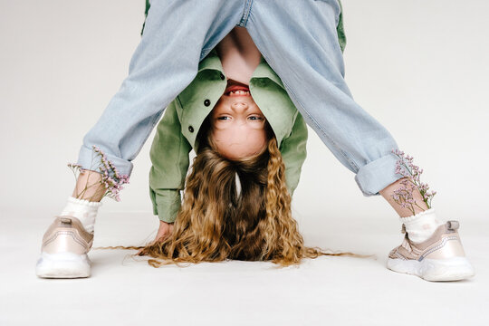 Playful girl upside down with flowers in sneakers