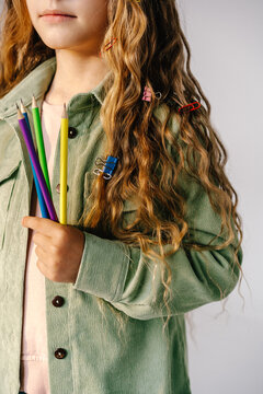 Close-up of girl holding colored pencils
