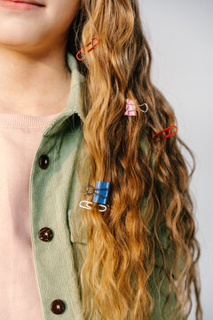 Close-up of girl&rsquo;s hair decorated with paper clips and binder clips