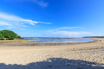 Beach with a clear blue sky and a few clouds
