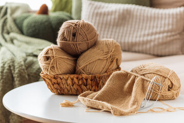 Knitting Basket with Yarn and Needles on White Table in Cozy Interior