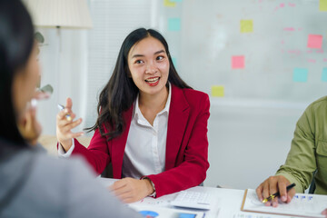 Asian businesswoman talking and gesturing during a business meeting. Professionals collaborating in a modern office setup