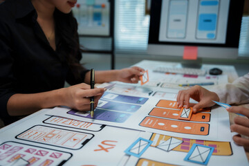 Web designers collaborating on mobile application development, planning user experience, and creating interface wireframes