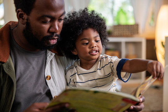 Father and child reading a book together.
