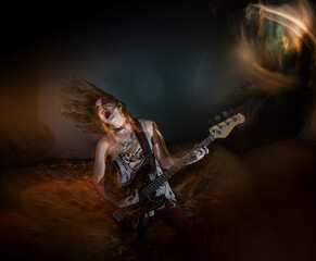 A female rocker with gothic makeup performing metal music during Halloween