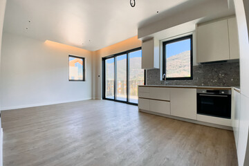 Modern, Spacious Kitchen and Living Area with Large Windows Offering a View of Nature and Abundant Natural Light