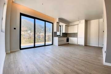 Obraz premium Modern and Spacious Interior Design of an Unfurnished Living Room with Floor-to-Ceiling Windows Overlooking Scenic Mountain View