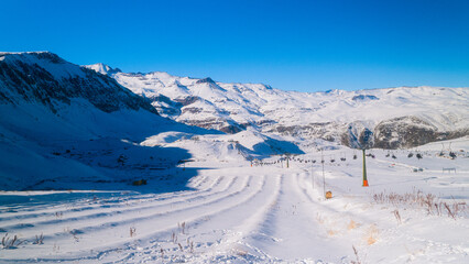Wide landscape of Farellones, Chile, showing a snowy slope with mountains in the background