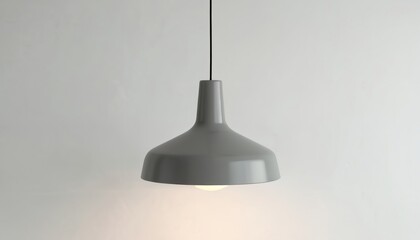 Grey pendant light hangs from ceiling in studio setting. Simple design illuminates white background creating soft glow. Modern interior lighting fixture offers clean aesthetic appeal for home office.