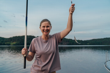 Woman Celebrating a Catch While Fishing on a Peaceful Lake