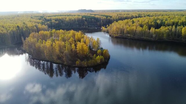 An aerial view of a vibrant autumn forest with a winding river cutting through it. Symbolizes change, beauty, and the cyclical rhythm of nature.