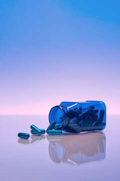 Blue pills spilling from a bottle, possibly for health treatment
