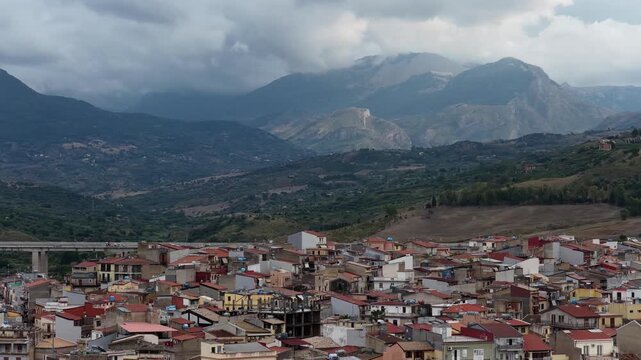 Aerial drone view of Campofelice di Roccella, a historic Sicilian village in Palermo,Sicily, Italy, featuring traditional stone houses, the Madonie Mountains, and the iconic highway viaduct