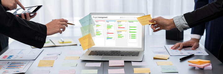 Analyst team use sticky note for creative and analytic brainstorm for business idea with BI data dashboard on laptop screen. Analysis financial data visualization tech for marketing strategy. Prodigy