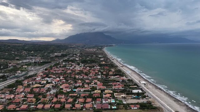 Aerial drone view of Campofelice di Roccella, a charming Sicilian seaside village in northern Sicily, Italy, showing traditional holiday homes, coastline, and panoramic Tyrrhenian Sea vistas