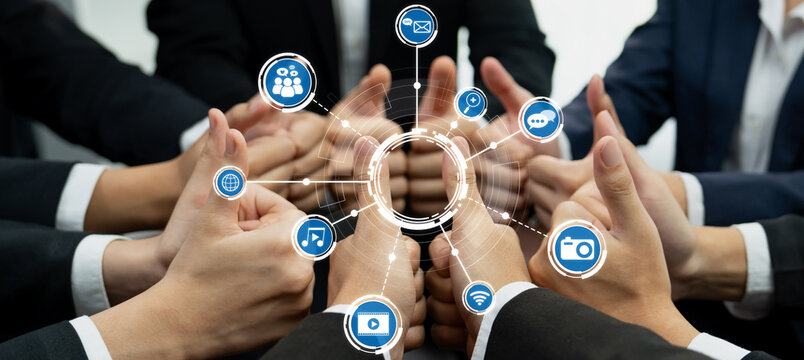 A dynamic group of professionals demonstrates teamwork with thumbs up, surrounded by digital media icons symbolizing communication, collaboration, and modern workplace connectivity. Amity - Powered by Adobe