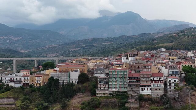 Aerial drone view of Campofelice di Roccella, a historic Sicilian village in Palermo,Sicily, Italy, featuring traditional stone houses, the Madonie Mountains, and the iconic highway viaduct