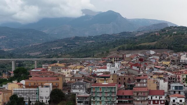 Aerial drone view of Campofelice di Roccella, a historic Sicilian village in Palermo,Sicily, Italy, featuring traditional stone houses, the Madonie Mountains, and the iconic highway viaduct